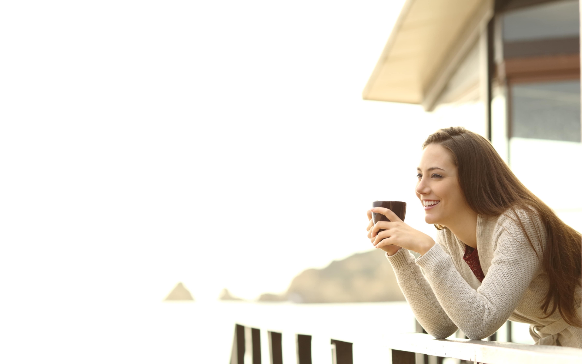 Woman drinking coffee on hotel balcony